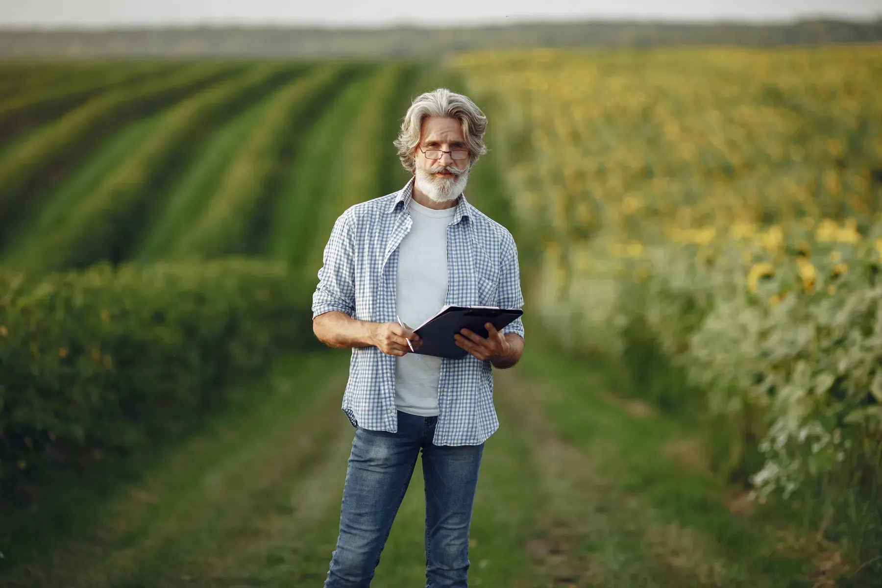 Landwirt nutzt ein Tablet mit einer digitalen Ackerschlagkartei auf dem Feld